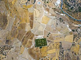 Aerial view on a green football field during drought on sifnos island, Greece